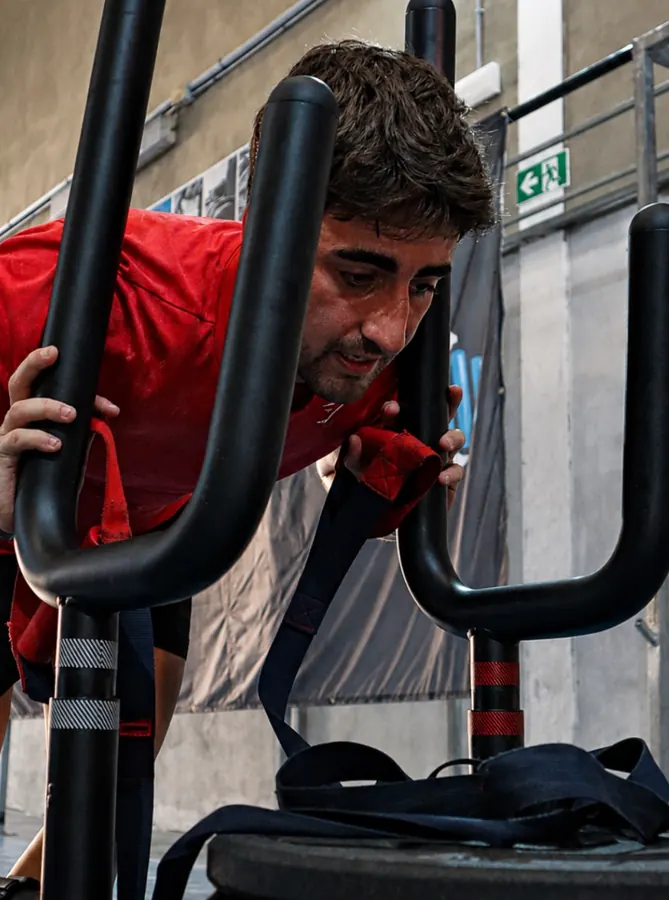 Deportista haciendo zancadas con un saco a la espalda